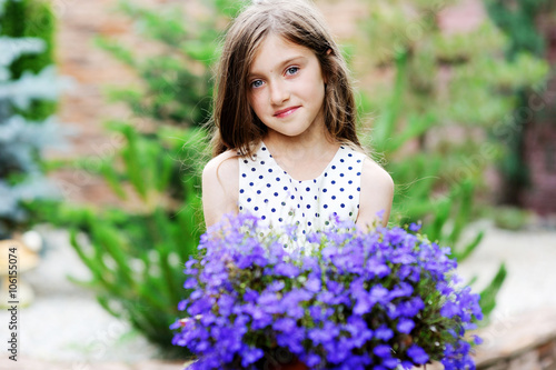 Adorable smiling kid girl with flowers