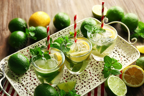 Mojito drinks with lime, lemon and mint on patterned tray
