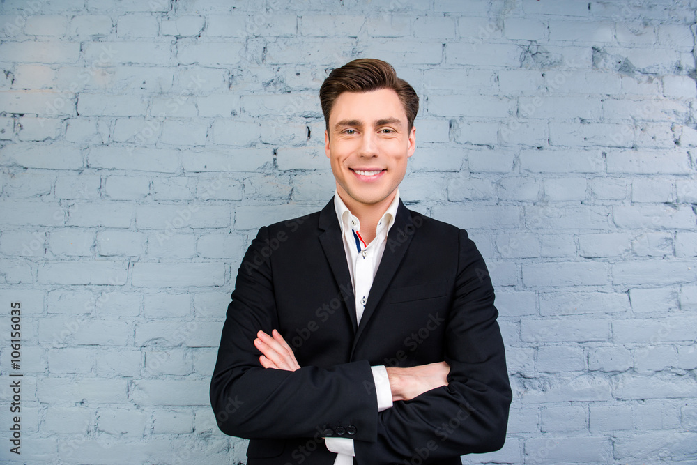 Portrait of handsome businessman with beaming smile and crosed h Portrait of handsome businessman with beaming smile and crosed h