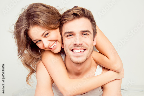Cheerful smiling couple in love hugging in the bedroom