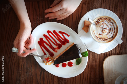 Woman with tasty chocolate cake on table in cafe or restaurant photo