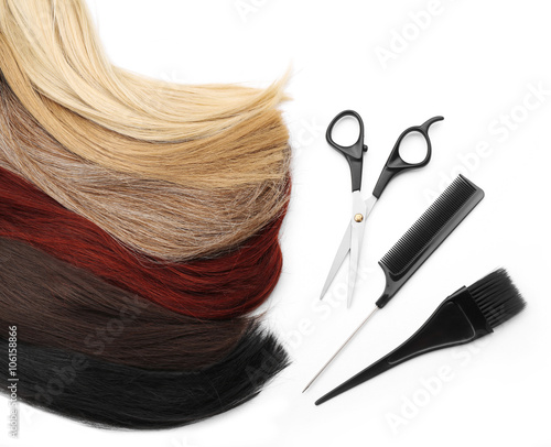 Hairdresser's scissors with tools and varicolored strands of hair, isolated on white
