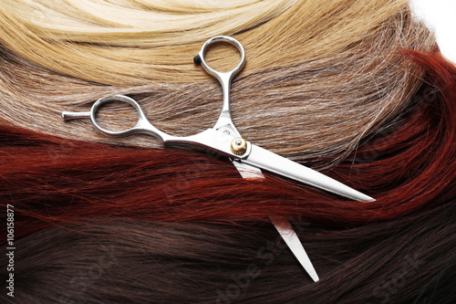 Hairdresser's scissors with varicolored strands of hair, close up