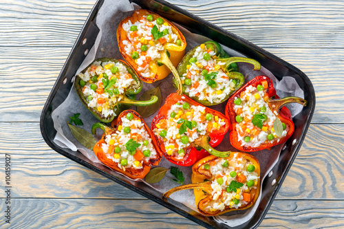 Canvastavla bell pepper stuffed with rice, green peas, carrots, top view