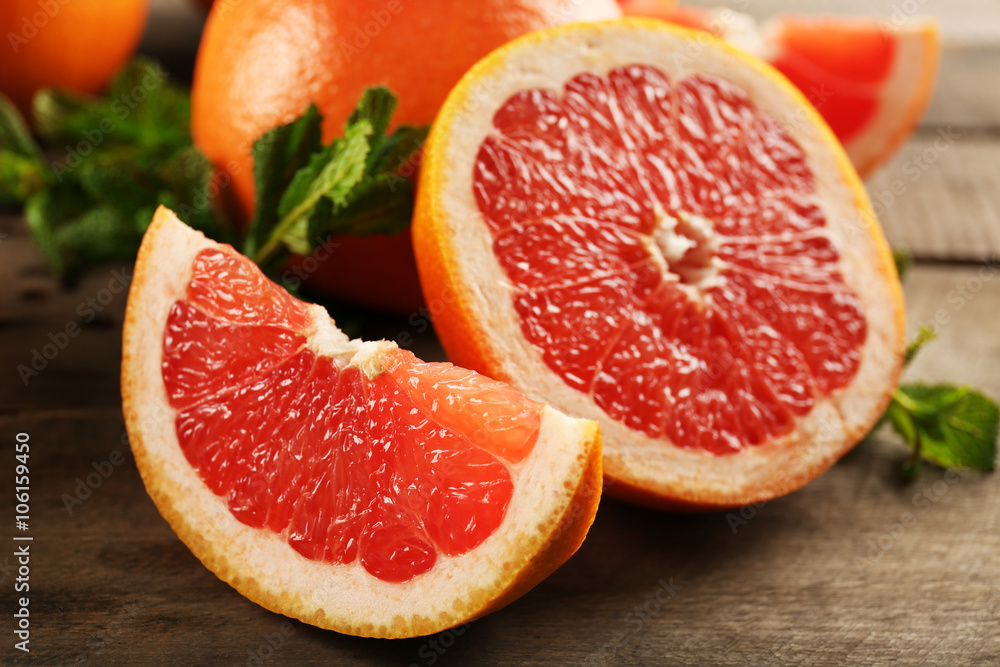 Sliced grapefruits with mint on wooden background, close up Sliced grapefruits with mint on wooden background, close up