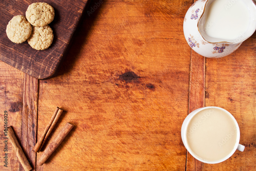 Food frame with coffee, milk, cinnamon and oatmeal cookies on wooden table Food frame with coffee, milk, cinnamon and oatmeal cookies on wooden table