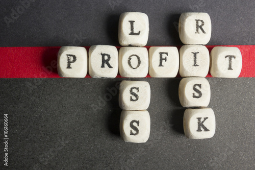 Profit  loss and risk crossword blocks on table. Top view
