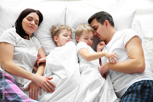 Family sleeping in bed, closeup