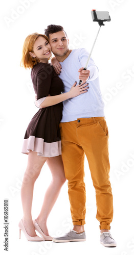 Young couple taking selfie with mobile phone isolated on white