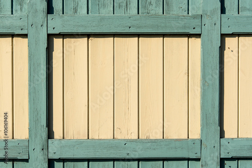 Section of green and yellow wood panelling from a beach hut, suitable for backgrounds of beach, seaside and summer holiday themes. Also gardening themes