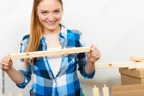 Woman assembling wooden furniture. DIY.