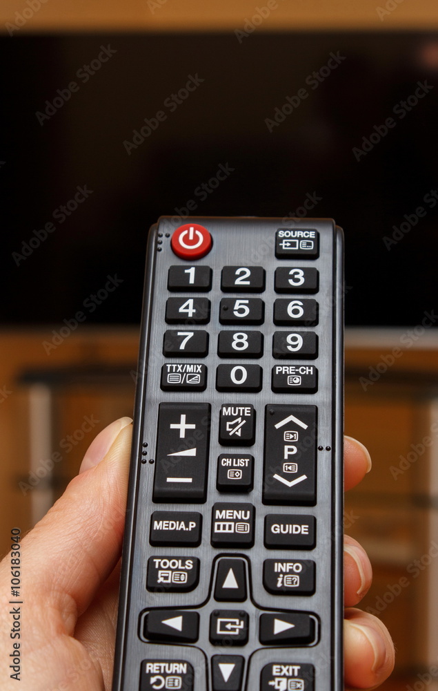 Hand holding remote control for television Hand holding remote control for television