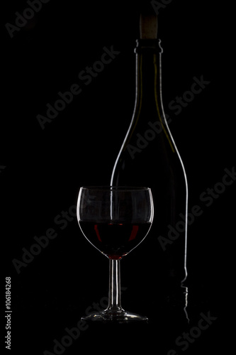 Bottle of wine and a glass of wine on a black background, minima