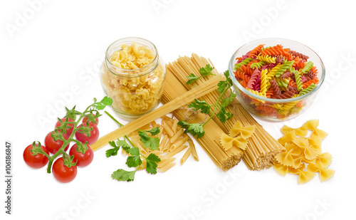 Several different uncooked pasta, sprigs of parsley and cherry t photo