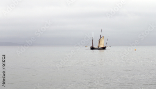 Ancient fishing boat, a Cornish lugger, becalmed off Newlyn, Cornwall, England, UK.