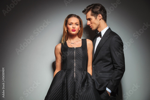 businessman and woman posing with hands in pockets