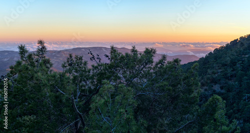 Panoramic view on mountain range with layer mist on evening glow background. Troodos, Cyprus. 