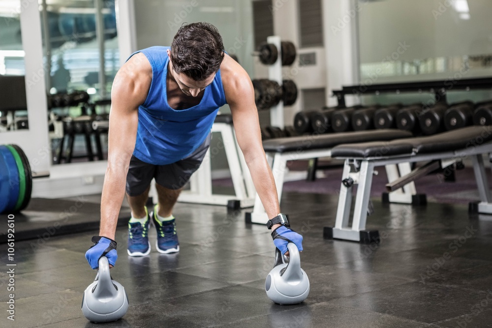 handsome man doing push ups with kettlebells handsome man doing push ups with kettlebells
