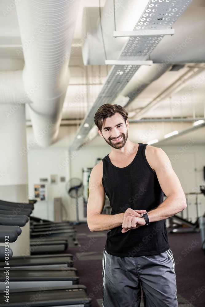 Smiling man on treadmill looking at smartwatch Smiling man on treadmill looking at smartwatch