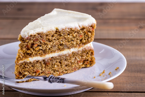 A slice of carrot cake on a white plate