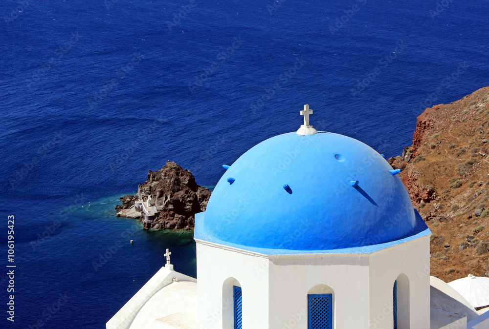 The island Santorini in Greece. Greek church with blue roof, sea. Top view.