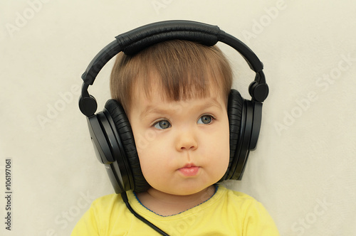 little girl with headphones listening music