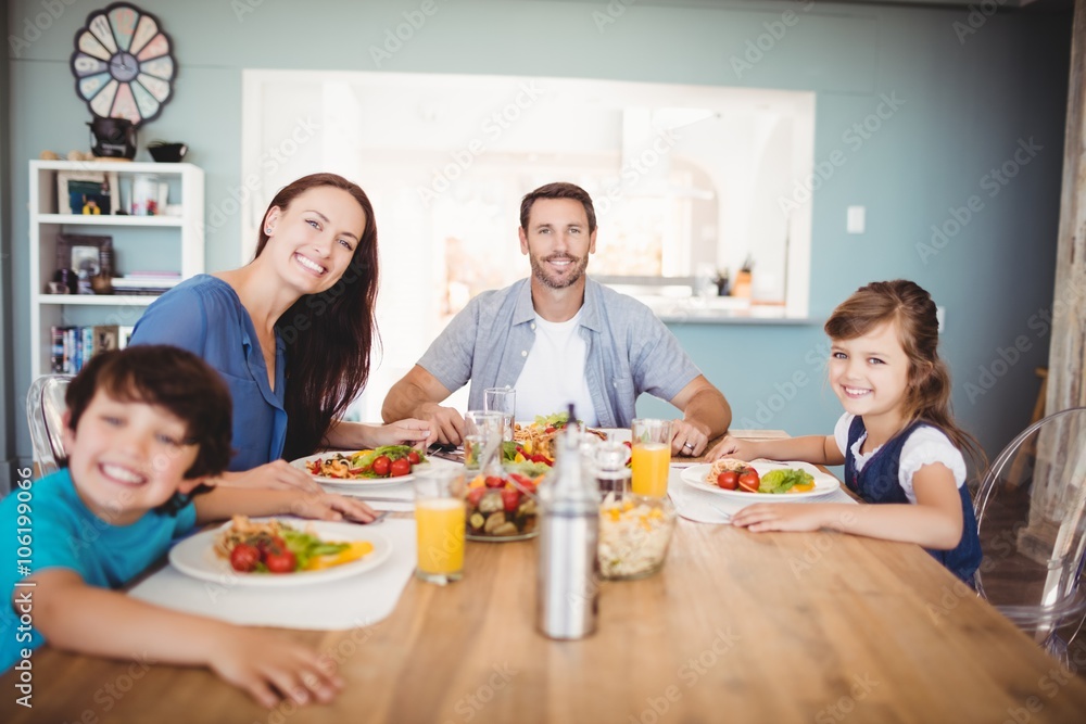 Portrait of smiling family with food on dining table