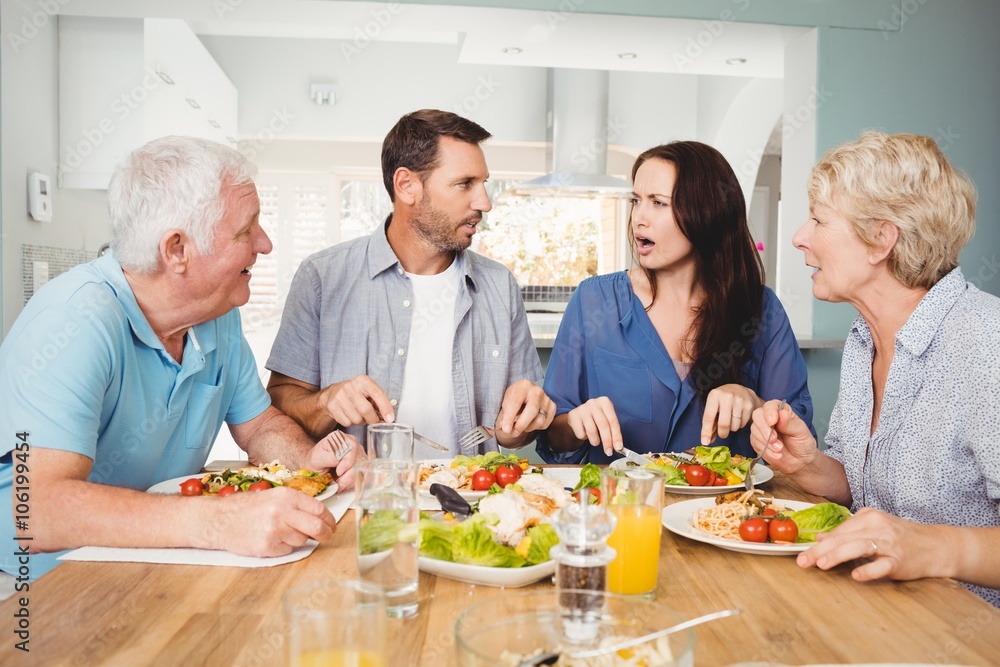 Family discussing while sitting at dining table