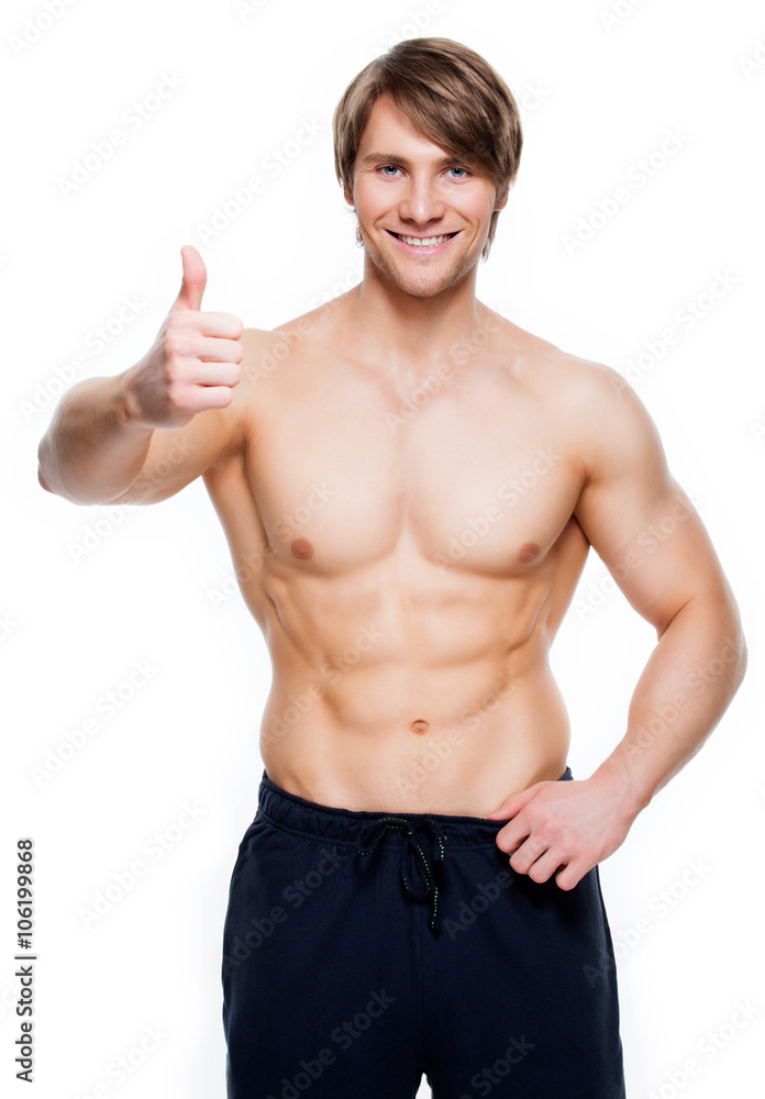 Man with muscular torso shows thumbs up sign. Man with muscular torso shows thumbs up sign.