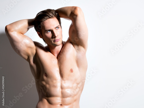 Muscular handsome man with hands behind head.