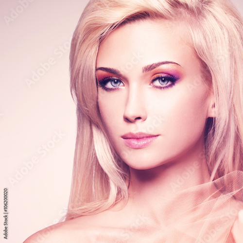 Sensual blonde woman covering by beige fabric.
