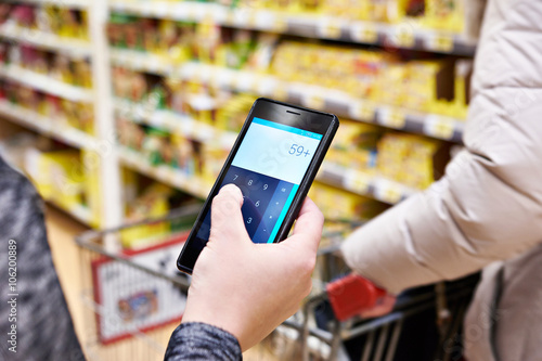 Calculator on smartphone screen in hand of women customers