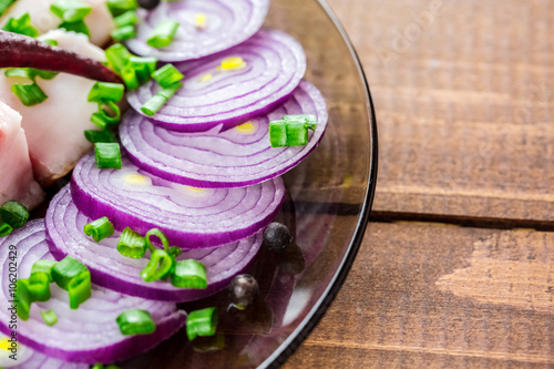 Fresh pork fat, with red hot chili peppers, green and purple onions and  peas allspice beautifully laid out on a glass plate on the background of old boards photo