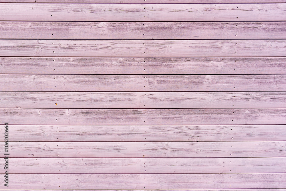 Obraz premium Section of textured pink wood panelling from a seaside beach hut. Could be used as a background to illustrate beach and summer holiday themes. 