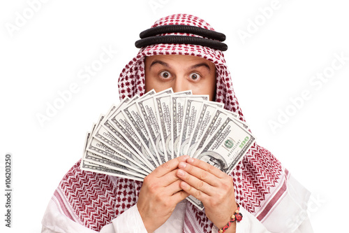 Arab hiding behind a stack of money photo