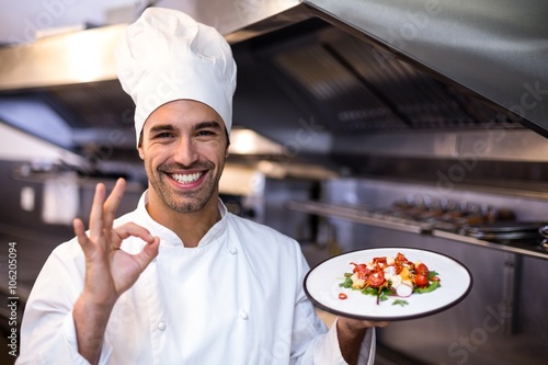 Handsome chef showing ok sign and meal photo