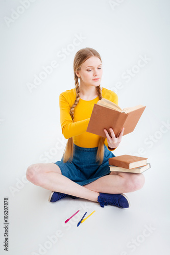 Student sitting on the floor and reading book