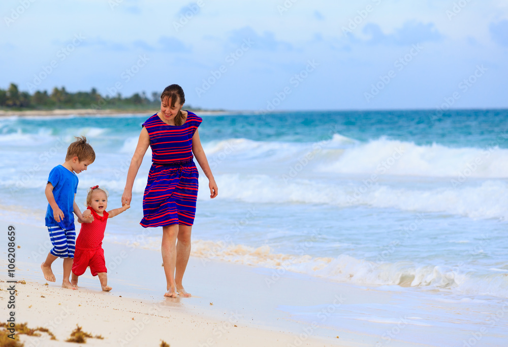 mother and two kids walking on the beach