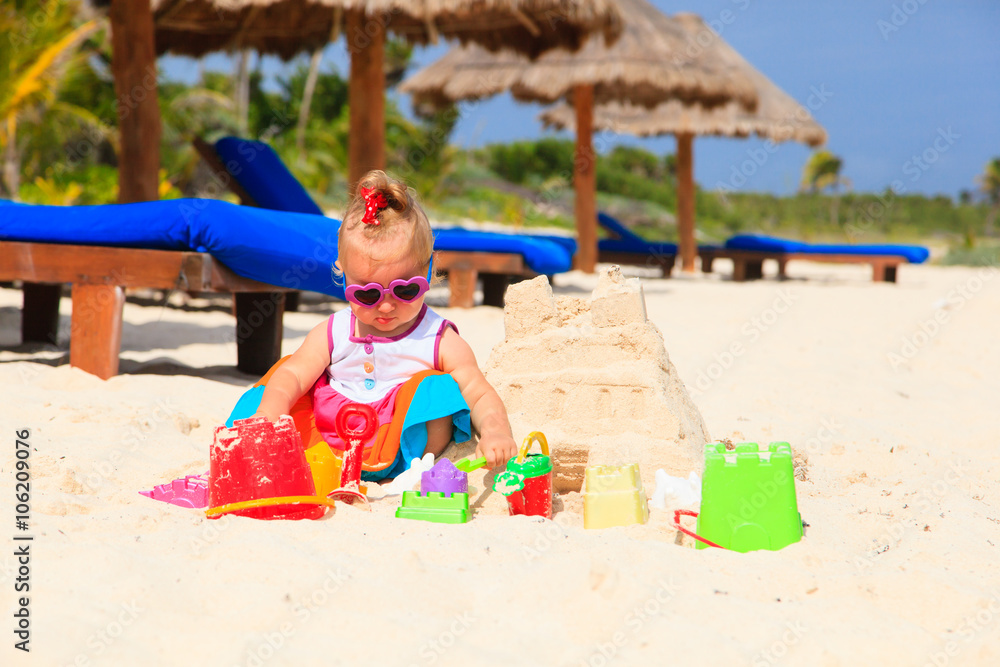 cute little girl building sandcastle on beach cute little girl building sandcastle on beach