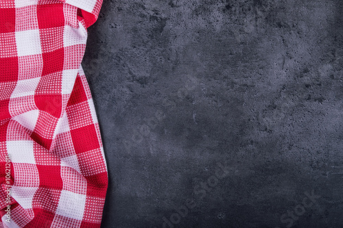 Top view of checkered kitchen tablecloth on granite -  concrete - stone background. Free space for your text or products.