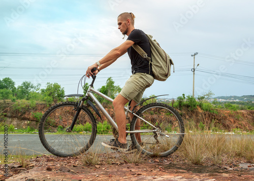 Young man riding bicycle in mountainous country