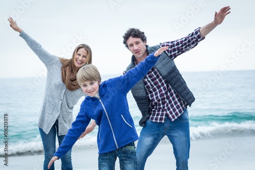 Family enjoying at sea shore against sky