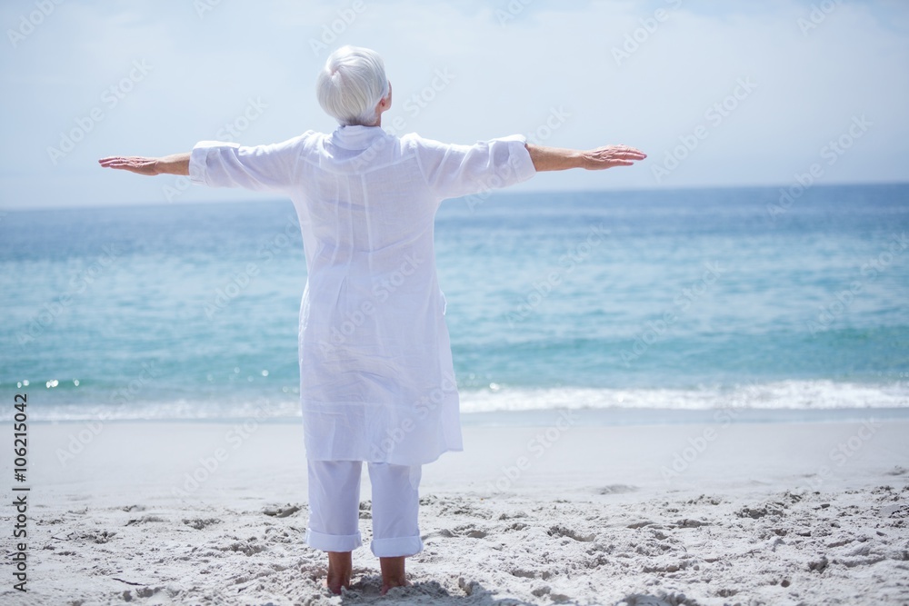 Senior woman exercising at sea shore on sunny day Senior woman exercising at sea shore on sunny day