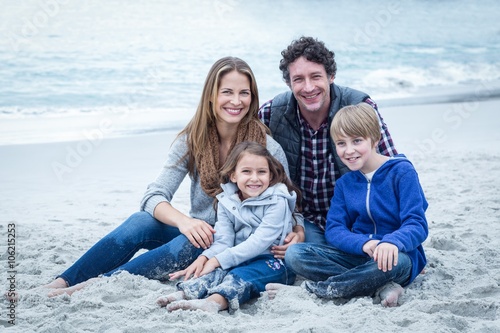 Parents relaxing with children at sea shore