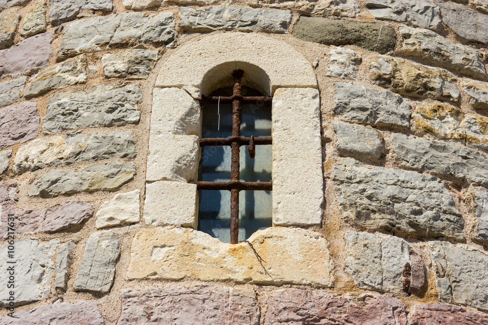 Ancient window with cell in the stone wall.