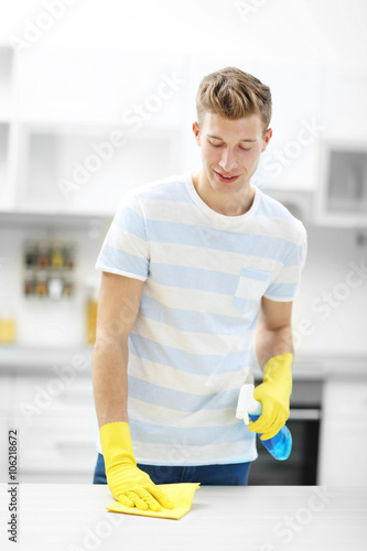 Handsome man cleaning kitch...