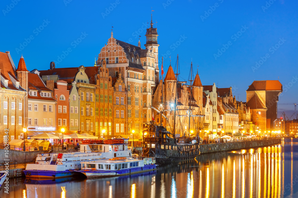 Fototapeta premium Tourist ships, Mariacka Gate and Zuraw in old town of Gdansk, Dlugie Pobrzeze and Motlawa River at night, Poland