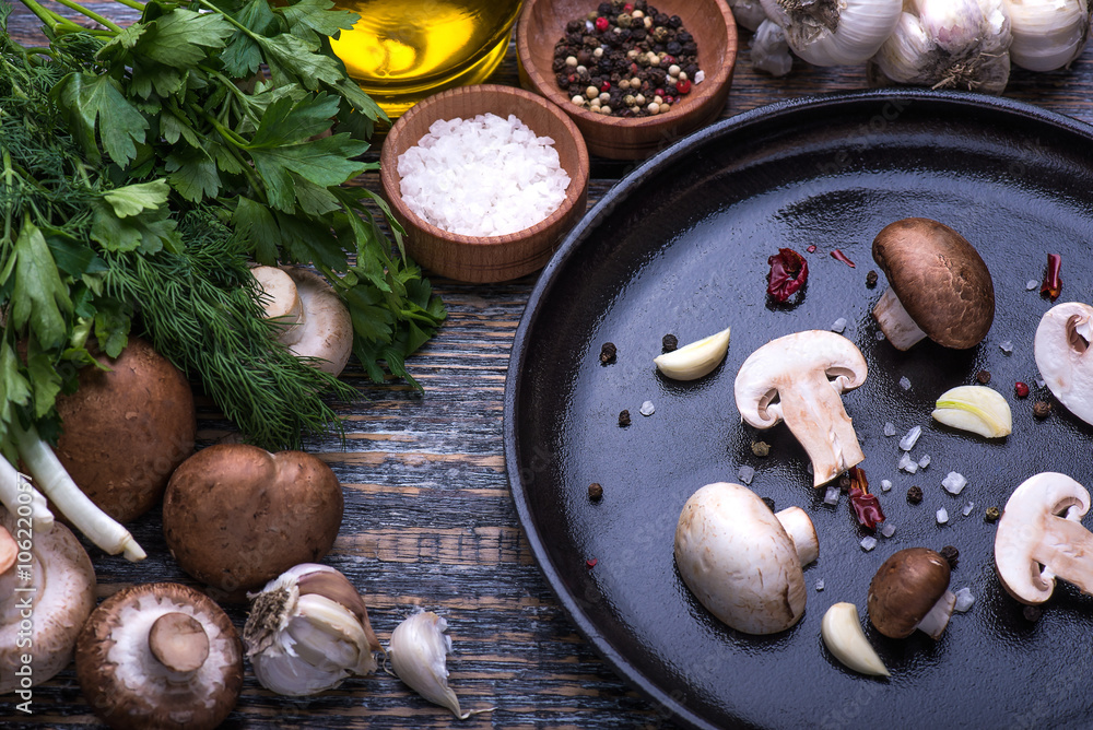 Fototapeta premium Mushrooms, parsley, dill, onion, olive oil, spices - ingredients for the preparation of mushroom dishes on the wooden background
