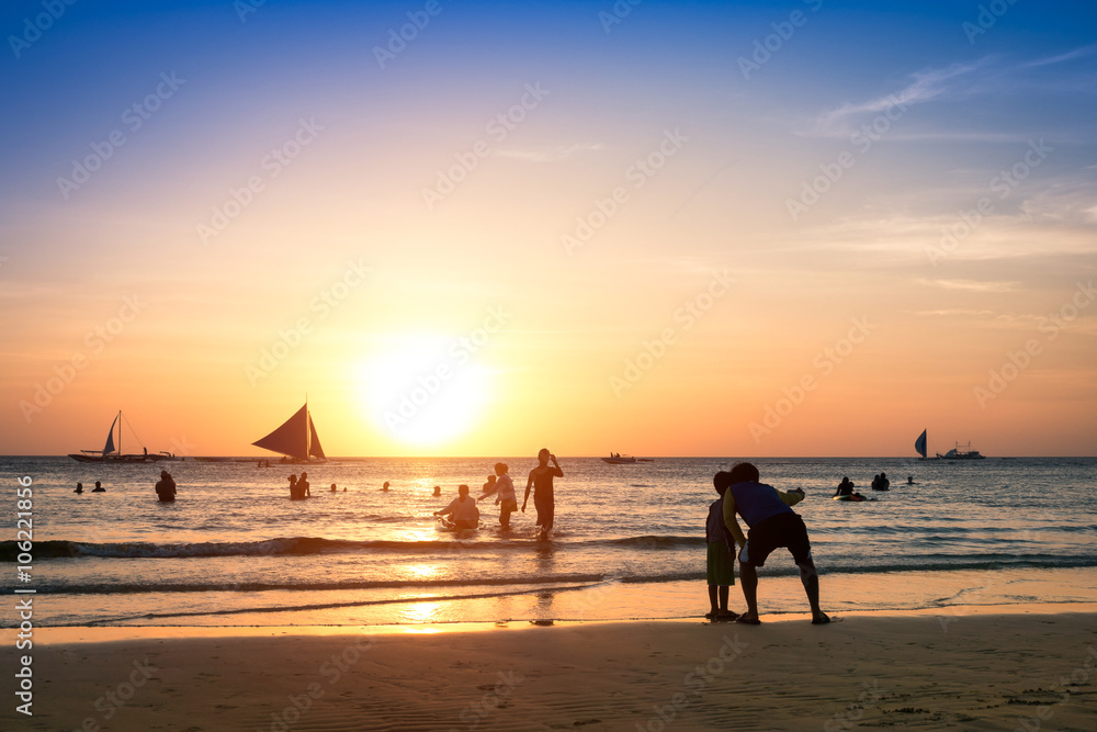 Silhouette of unrecognizable tourists and local people with father and son taking selfie at Boracay beach during sunset - Exclusive travel fun destination in Philippines - Warm enhanced filtered look Silhouette of unrecognizable tourists and local people with father and son taking selfie at Boracay beach during sunset - Exclusive travel fun destination in Philippines - Warm enhanced filtered look