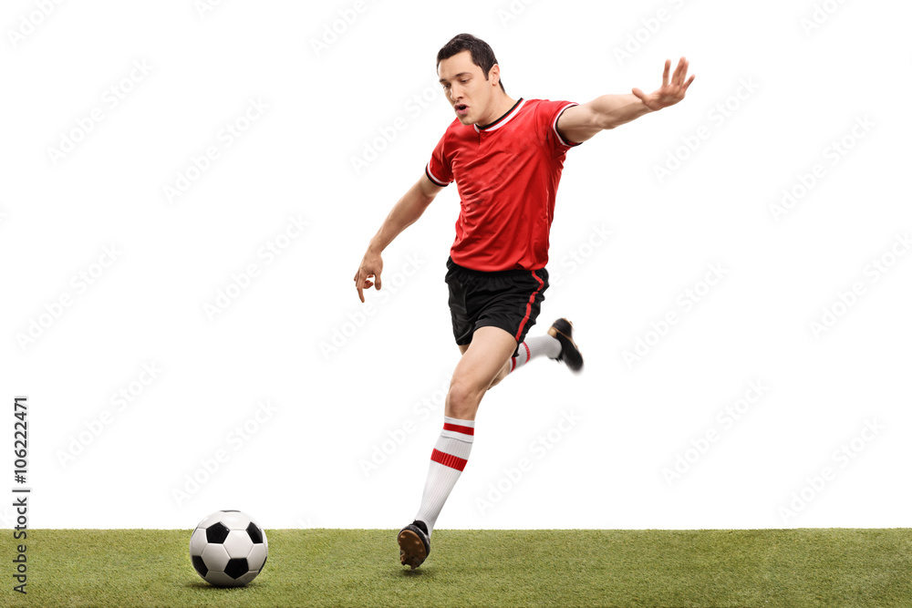 Young football player kicking a ball